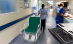 A blurred out view of hospital staff on an NHS ward