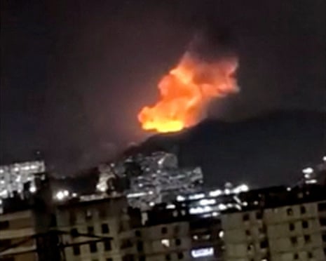 A column of smoke rises during multiple explosions in the early hours of the morning, in Caracas, Venezuela.