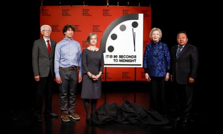 Members of the Bulletin of the Atomic Scientists pose for a photo with the 2023 Doomsday Clock which is set at ninety seconds to midnight.