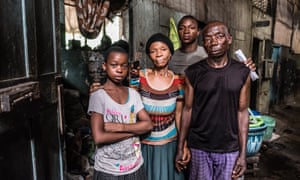 Theresa and Usua Peters and their children, outside the one room they shared before they were thrown out.