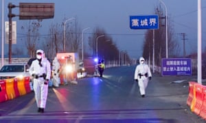 Police officers and staff members in protective suits inspect vehicles at a checkpoint on the borders of Gaocheng district on a provincial highway, following a coronavirus outbreak in Hebei province, China.