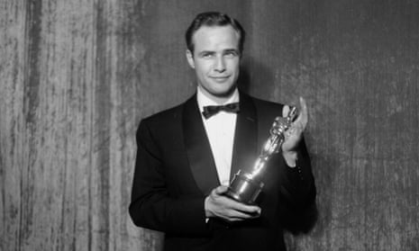 Marlon Brando poses backstage at the 27th Academy Awards holding an Oscar for his performance in the movie On the Waterfront on March 30, 1955 in New York City, New York.