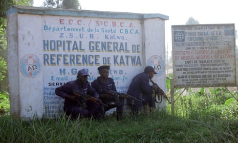 Police guards shelter behind a hospital sign in Butembo the day after an Ebola treatment centre in the city’s Katwa district was attacked by militia