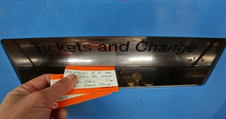 A man collecting train tickets from a machine