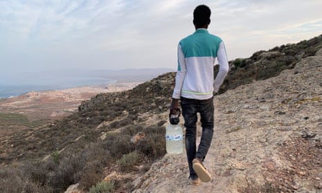 18-year old Malian refugee carrying a water bottle refilled in a spring, walks back to a migrant camp in Gurugu Mountain, Morocco, 25 September 2020.