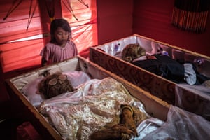 In contrast to Western norms, Torajans people, who live in the mountains of Sulawesi in Indonesia, treat their beloved relatives as if they are sick not dead. In this picture, a grandchild stands next to her deceased grandparents. Yohanis (right), was 77 years old and passed away two weeks ago; his wife Alfrida Tottong Tikupadang (left), was 65 years old and passed away five years ago. In Toraja, it is customary to feed the deceased every day and to keep the corpses cozily bedded in a separate room of the family house until the family can afford a proper funeral.