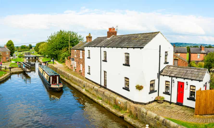 Narrowboat at lock with white cottages