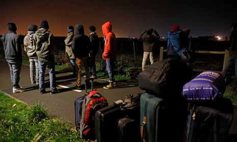 People at the now defunct refugee camp in Calais known as ‘the Jungle’ wait to be seen by the French authorities