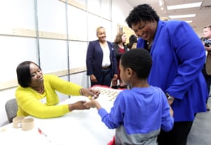 Abrams watches as her nephew receives a sticker after she voted early at the South DeKalb Mall in Decatur, Georgia.