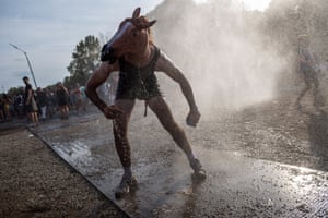 A festivalgoer cools himself with a mist machine in Budapest, Hungary