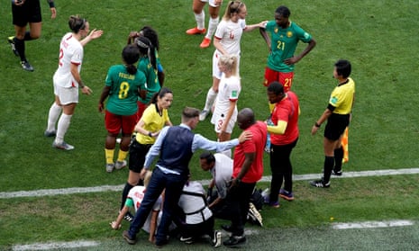 Referee Qin Liang approaches Phil Neville (bottom left) and Cameroon head coach Alain Djeumfa.