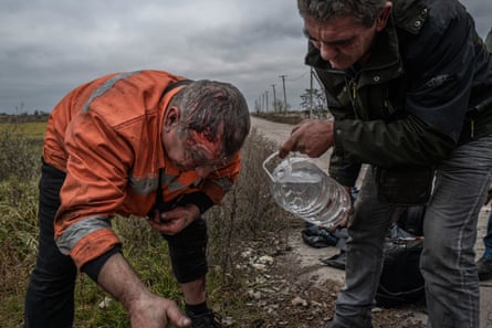 Railway workers wash their wounds after driving over a mine in the Kherson region, November 2022.