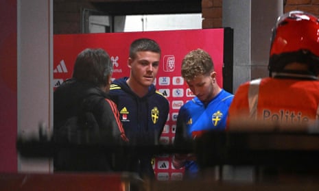 Swedish players Emil Holm and Samuel Gustafson wait to be escorted outside the King Baudouin Stadium after the match’s abandonment.