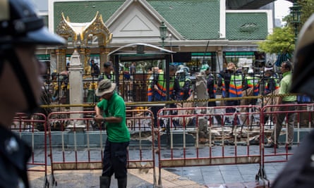 Policemen stand guard in front of the Erawan Shrine following the blast. 