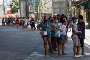 Shoppers queue outside a supermarket in Quezon City, Metro Manila, on Friday