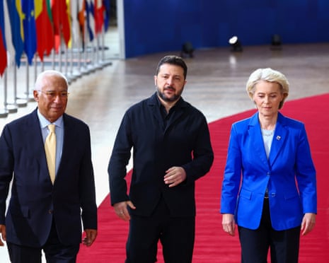 António Costa, Volodymyr Zelenskyy and Ursula von der Leyen walk along a red carpet in Brussels.