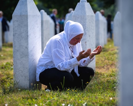 A woman prays among the gravestones at the memorial cemetery in the village of Potocari, near the eastern Bosnian town of Srebrenica.