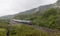 A train moving through countryside beneath chalk cliffs