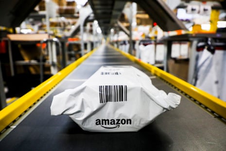 White plastic package with black lettering is the only thing on a conveyor built with yellow-painted metal guardrails.