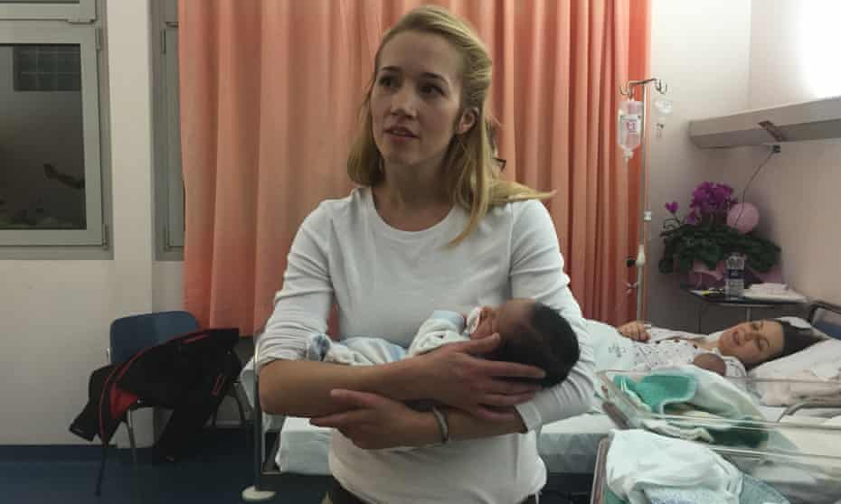 Help Refugees volunteer Crystallynn Steed Brown holds a newborn Afghan refugee.