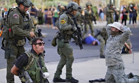 Albuquerque police detain members of the New Mexico Civil Guard, an armed civilian group, following the shooting.