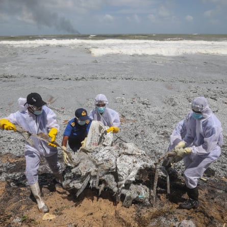 Sri Lanka navy personnel clear debris from the X-Press Pearl, which had 25 tonnes of nitric acid and other chemicals onboard.