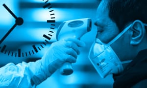 A person wearing a mask having their temperature taken