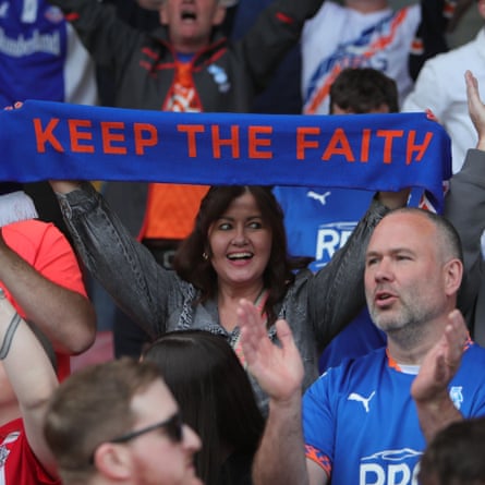 An Oldham fan holds up a scarf.