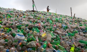 Female workers sort through polyethylene terephthalate bottles in a recycling factory in Dhaka, Bangladesh