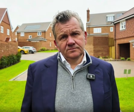 Simon Dudley standing in front of houses