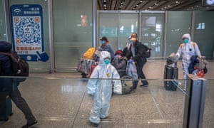 Coronavirus outbreak: passengers wearing protective masks and suits arrive at Beijing airport.