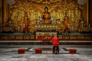 A man prays alone inside an almost empty Seng Guan temple in Manila, the Philippines