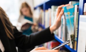 Girl looking at her phone in a bookshop