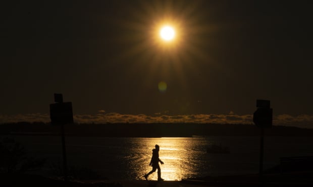 The sun shines over Casco Bay but does little to warm the frigid air for a walker in Portland, Maine. 