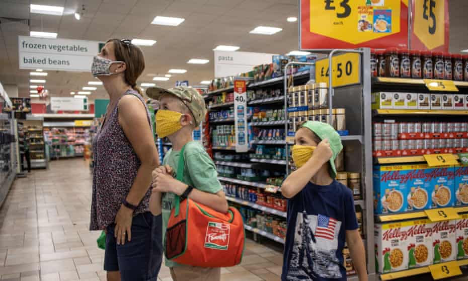 A family shopping in Morrisons supermarket wearing protective facemasks