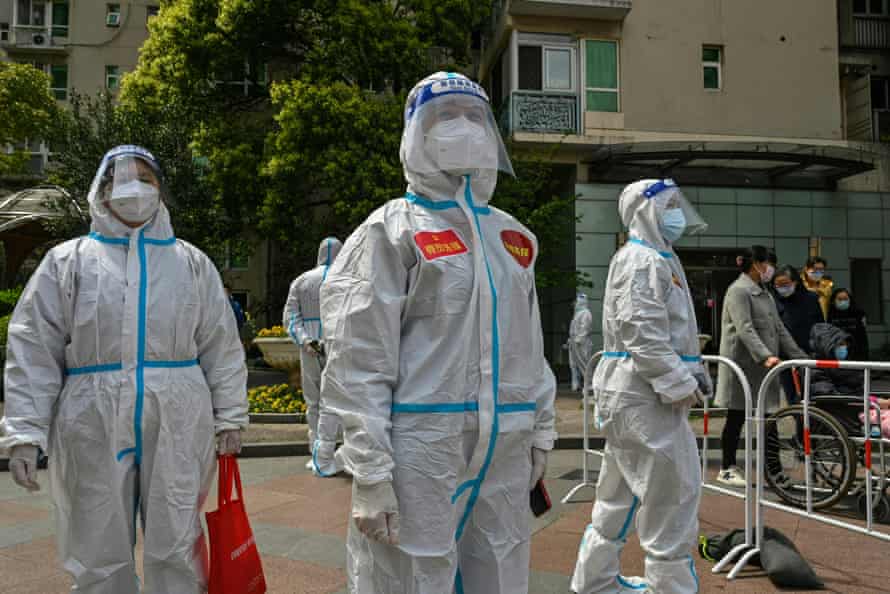 Workers and volunteers arrive to begin testing in a residential compound in Jing’ an district in Shanghai on Friday.