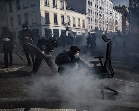 Demonstrators stand amid tear gas with fired by riot police during a high-school students protest as part of a nationwide protest movement over learning conditions in Lyon.