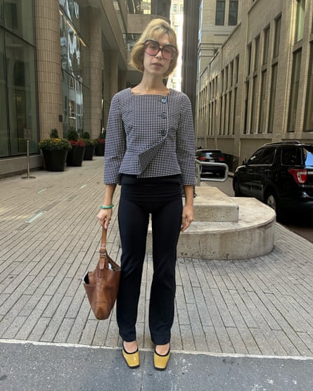 a woman in a plaid top and black pants