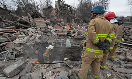 Ukrainian rescuers work among the rubble of a private building after shelling in Zaporizhzhia.