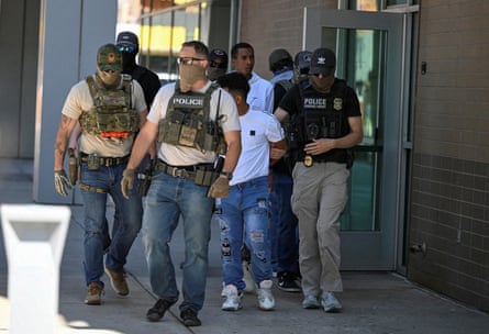 Law enforcement officers take people into custody at an immigration court in Phoenix.