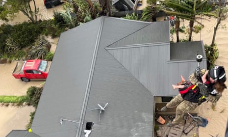 A stranded person is airlifted from their rooftop by a military helicopter in the Esk Valley near the North Island city of Napier on Tuesday.