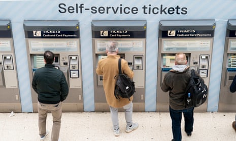 People use a ticket machine at Waterloo train station in London