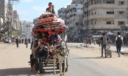 Palestinians on a horse and cart flee areas north of Gaza City in the Gaza Strip, 12 October 2024.