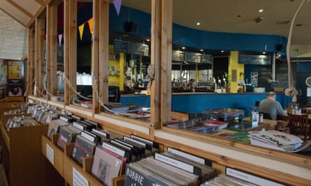 Interior of Mono, Glasgow. In the foreground are racks of music vinyl while in the background there is a cafe area.