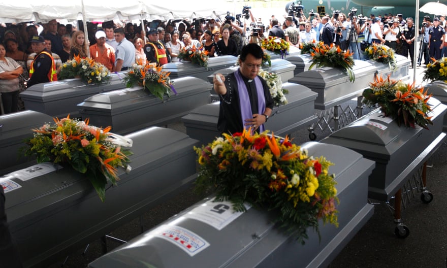 A priest blesses the coffins of 16 Hondurans, discovered with another 56 murdered migrants in a mass grave in San Fernando in 2010.