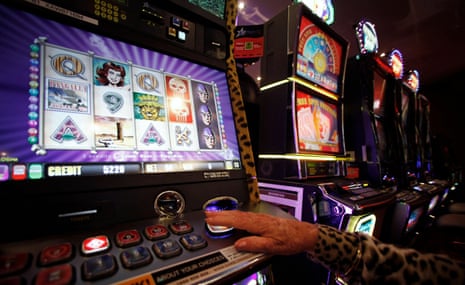 A person's hand playing a gambling machine