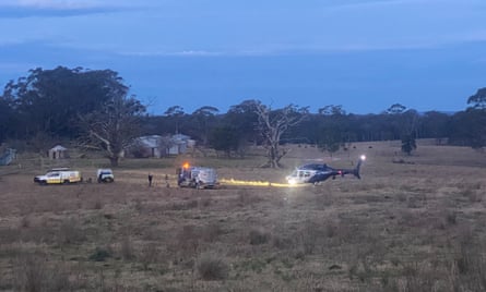 A solitary helicopter sits near the dwindling, demobilised search party.