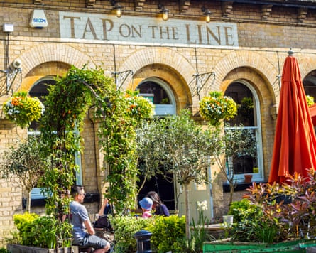 People sitting outside a pub in the sunshine.