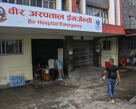 People speak with the police as they search for their missing relatives at Bir hospital in Kathmandu