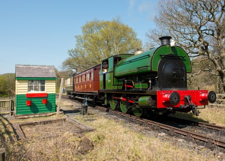 A steam engine and two carriages on a railway